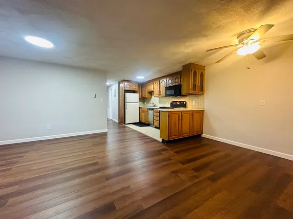 a kitchen with granite countertop a stove and a wooden floors