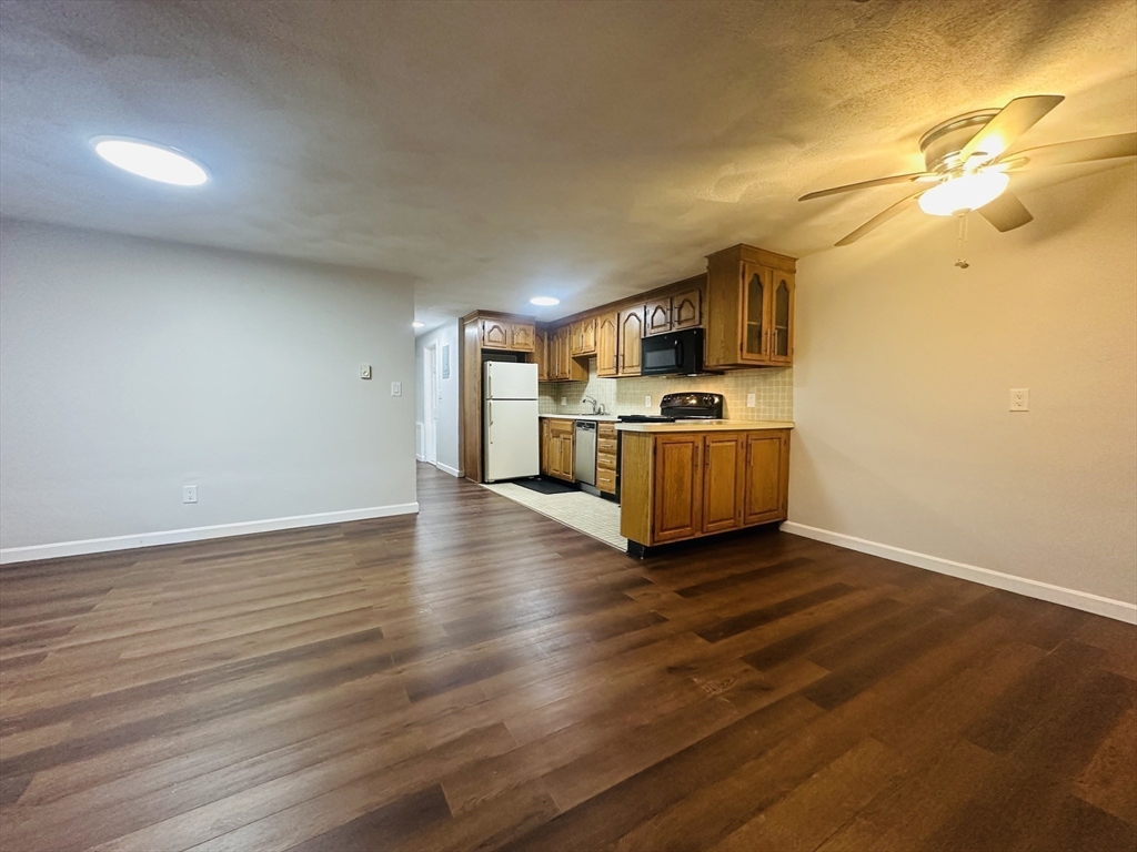 222 School Street, Unit 4 Walpole, MA 02081 - Photo 6 of 16 a kitchen with granite countertop a stove and a wooden floors