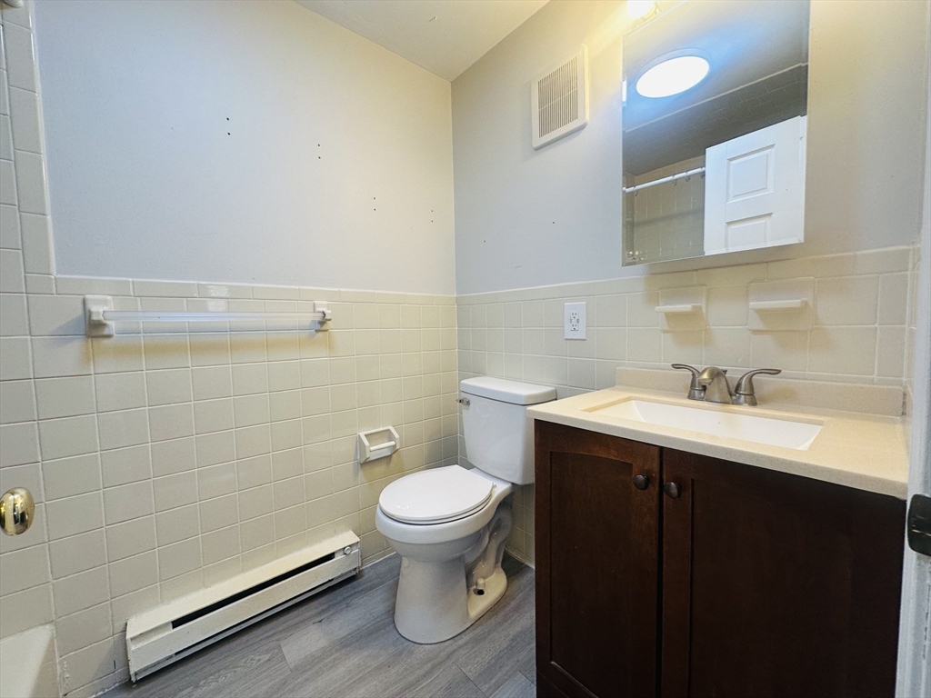 222 School Street, Unit 4 Walpole, MA 02081 - Photo 10 of 16 a bathroom with a sink toilet and vanity