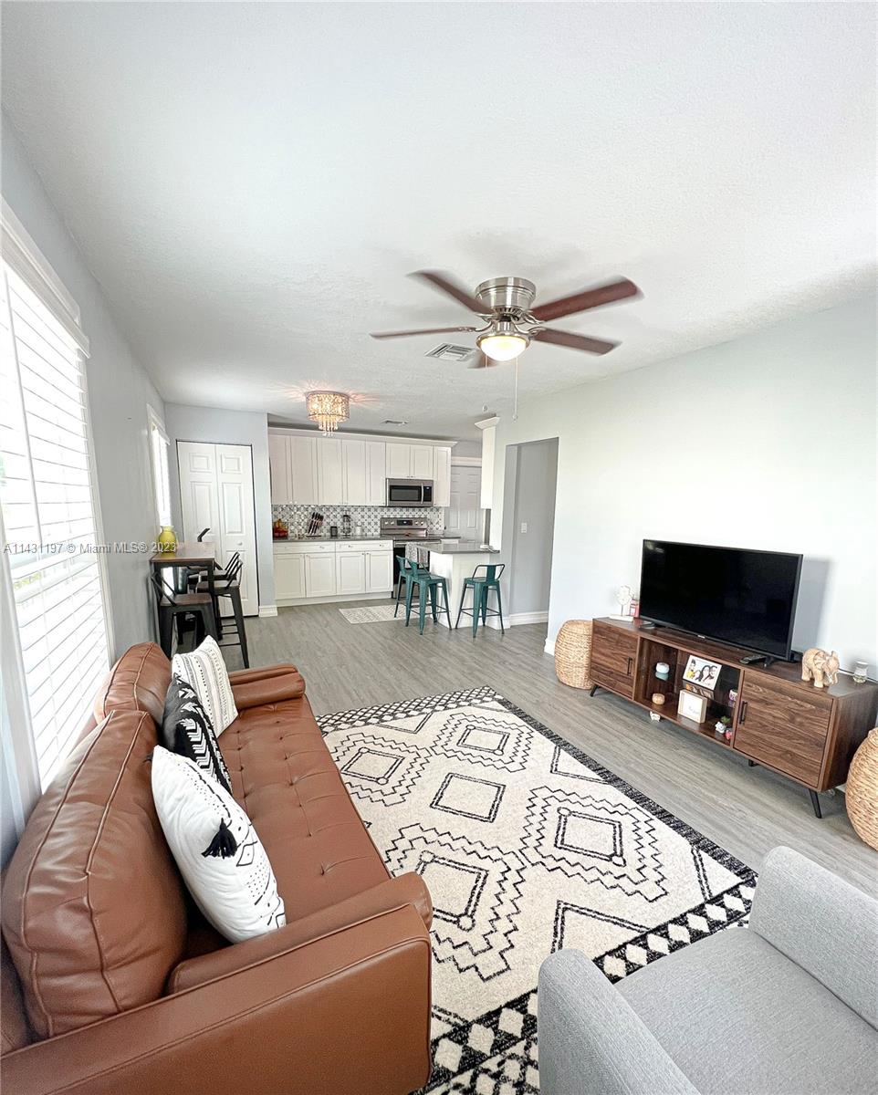 515 Valley Forge Road West Palm Beach, FL 33405 - Photo 2 of 9 a living room with furniture and a flat screen tv with kitchen view