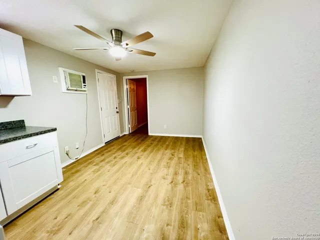 a view of a kitchen with wooden floor and a ceiling fan