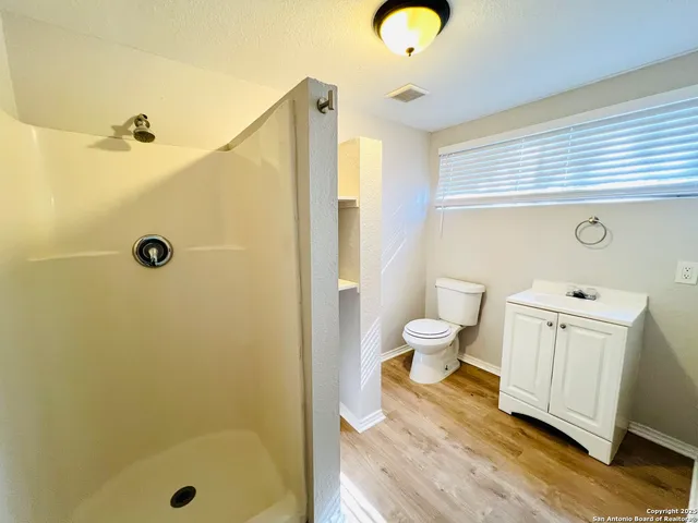 a bathroom with a sink a toilet and shower