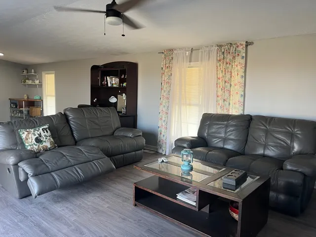 a living room with furniture and a wooden floor