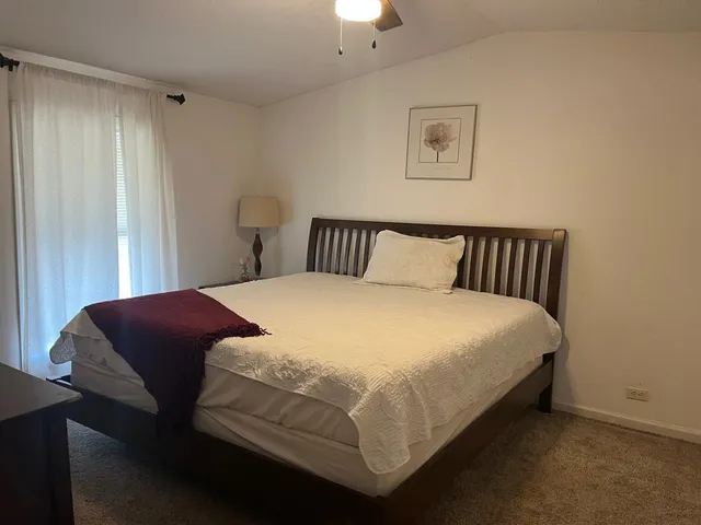 a bedroom with a bed and a lamp on desk