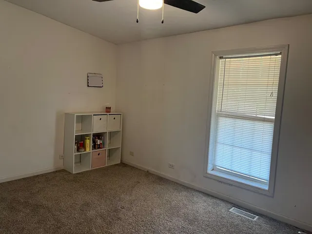 an empty room with windows and cabinet