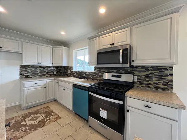 a kitchen with cabinets appliances and a window