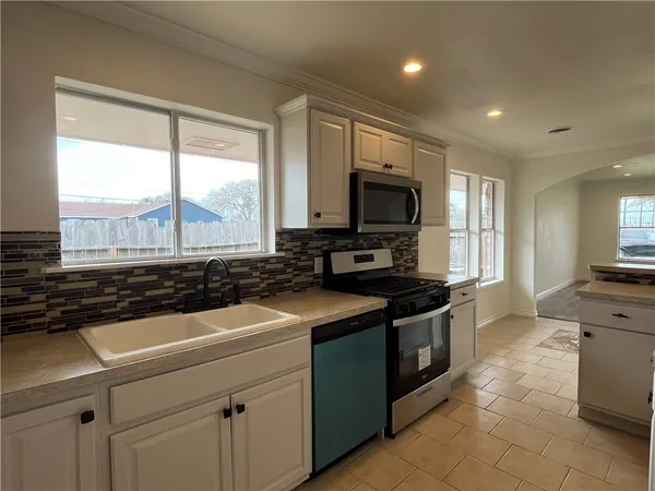 a kitchen with stainless steel appliances a stove sink and cabinets
