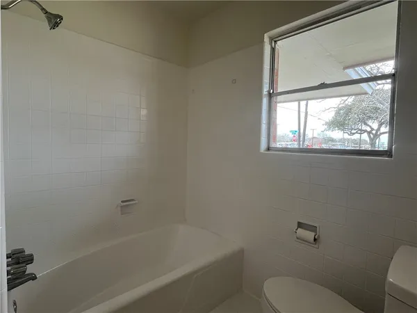 a white bath tub sitting next to a toilet