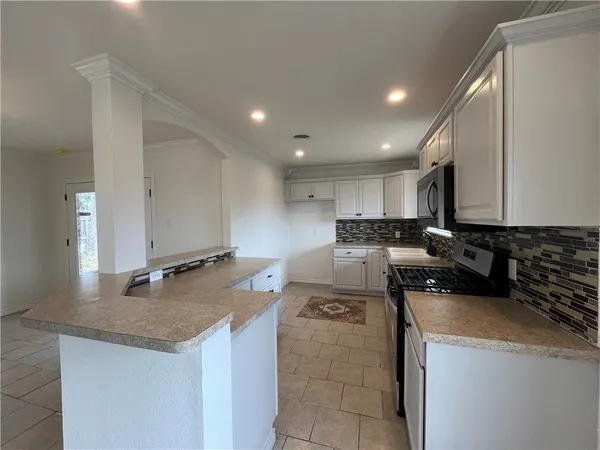 a kitchen with a sink a stove and cabinets