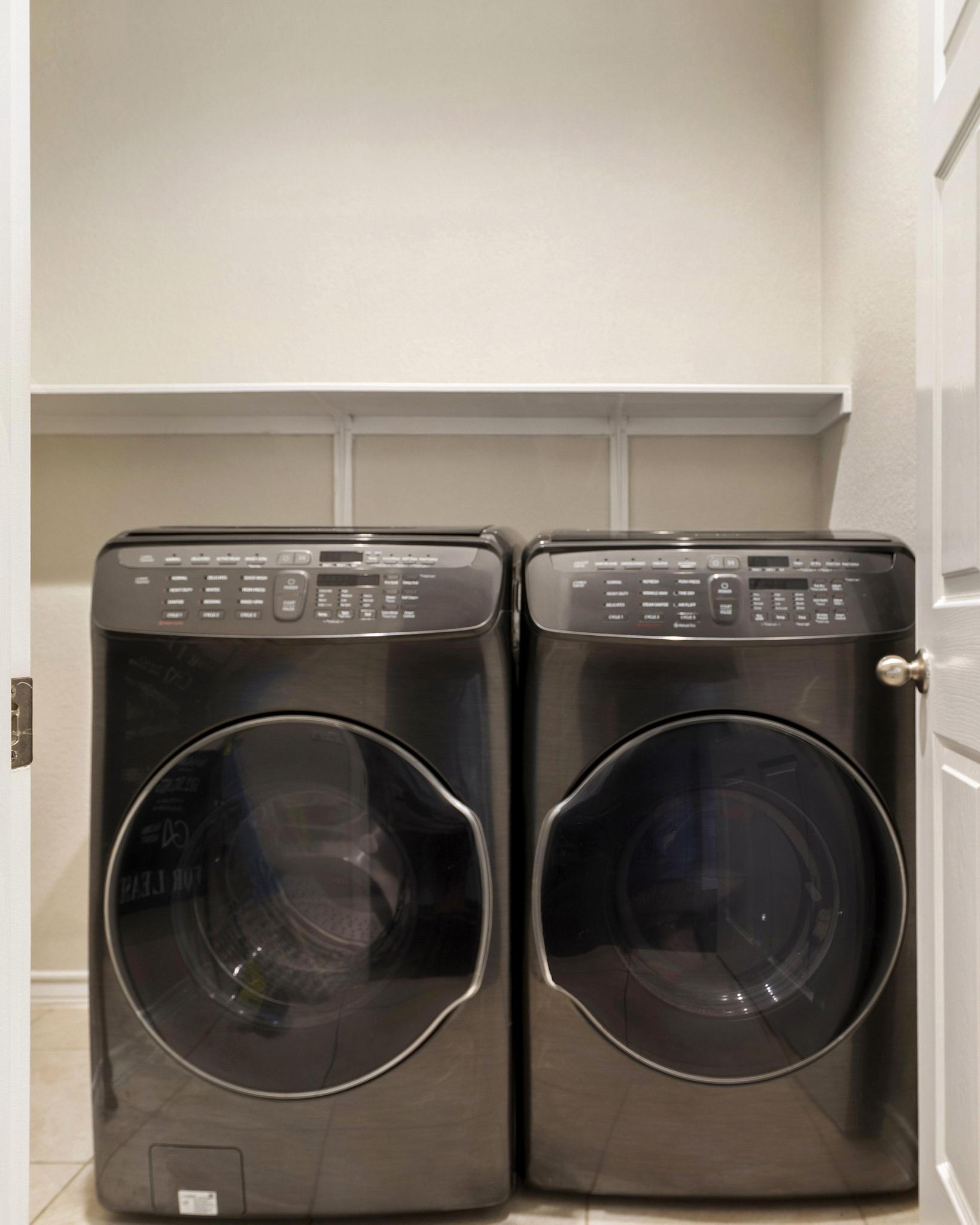 1341 Eagle Ray Street Leander, TX 78641 - Photo 24 of 37 Functional laundry space featuring modern machines and convenient shelving for household essentials.