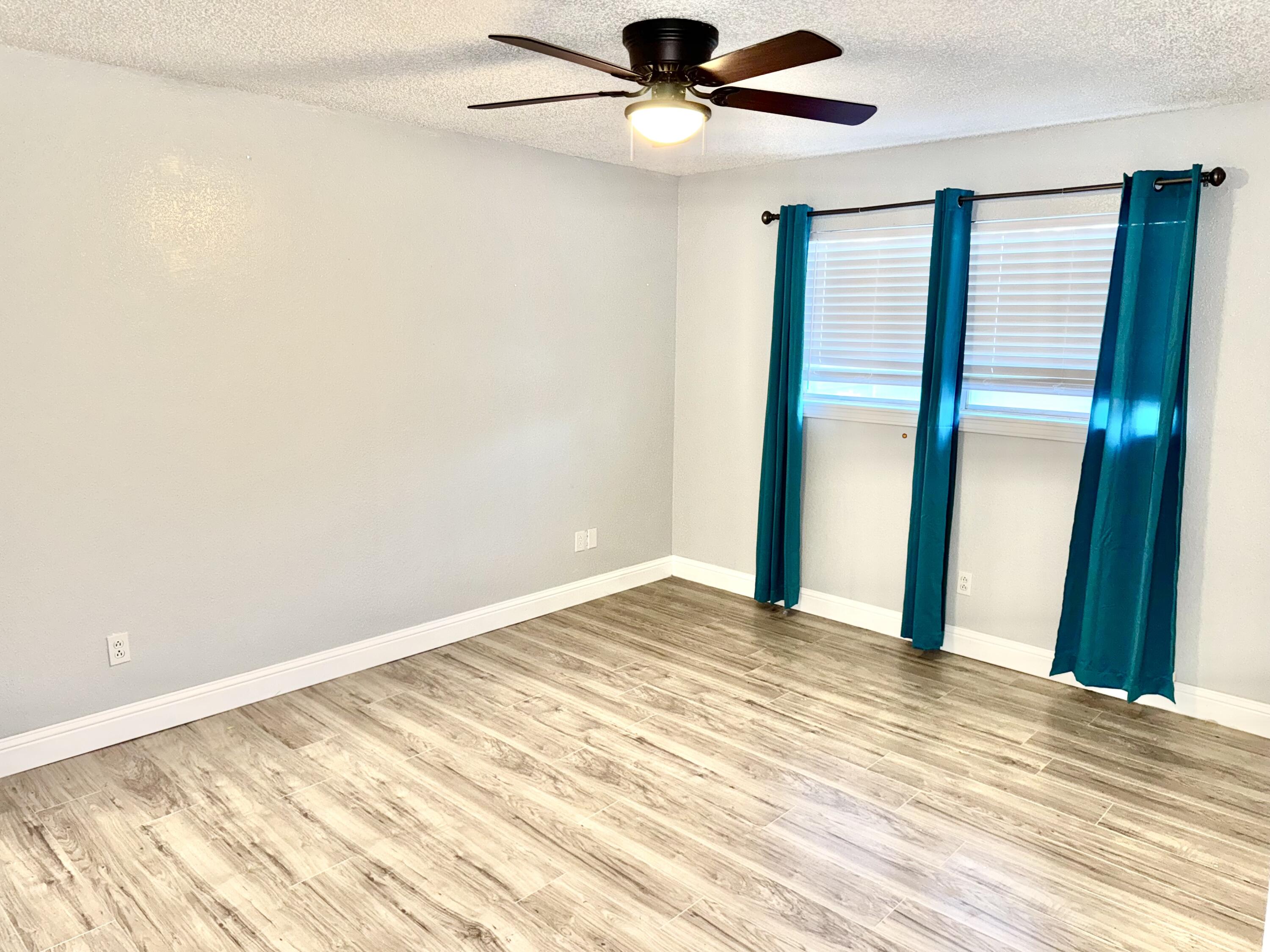 5415 73rd Street Lubbock, TX 79424 - Photo 11 of 13 an empty room with wooden floor fan and windows