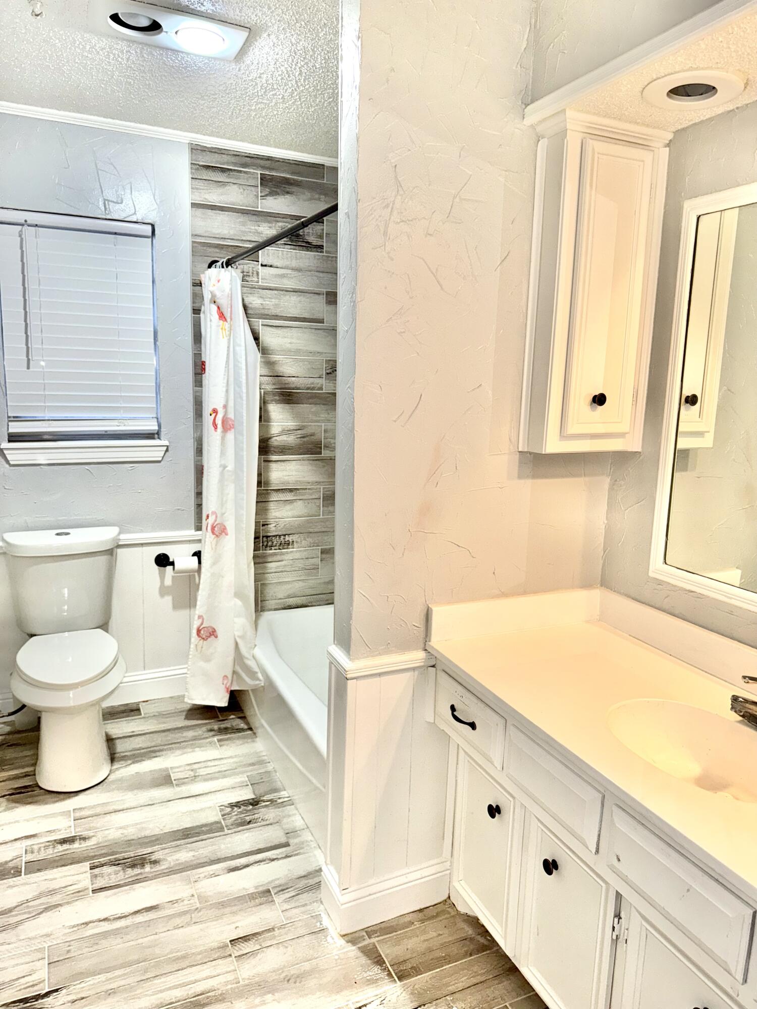 5415 73rd Street Lubbock, TX 79424 - Photo 12 of 13 a bathroom with a sink a toilet and a bathtub