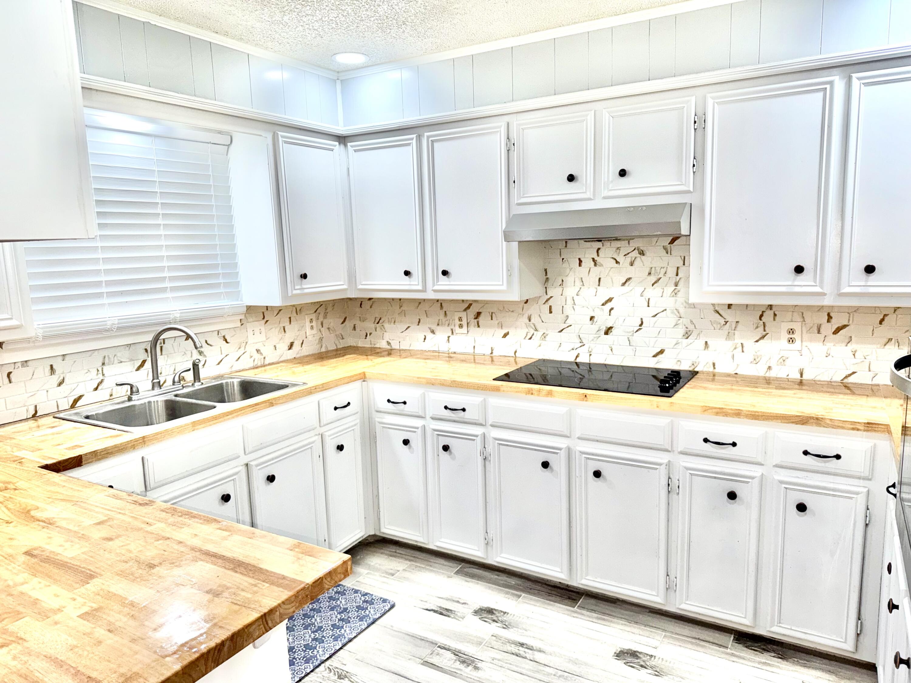 5415 73rd Street Lubbock, TX 79424 - Photo 9 of 13 a kitchen with granite countertop white cabinets and sink