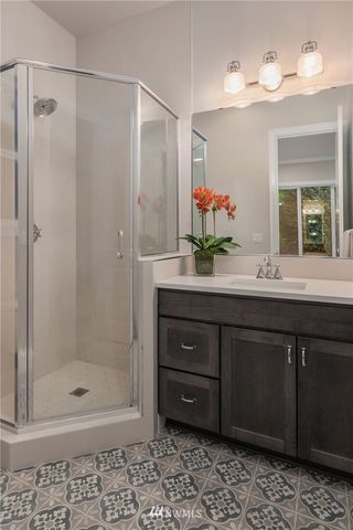 a bathroom with a double vanity sink mirror and shower