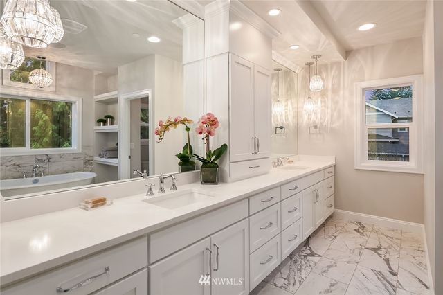 a bathroom with double vanity sinks a large mirror and a shower