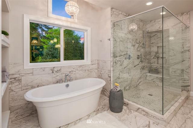 a white bath tub sitting next to a shower