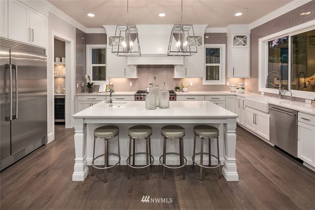 a kitchen with stainless steel appliances granite countertop a sink and a refrigerator