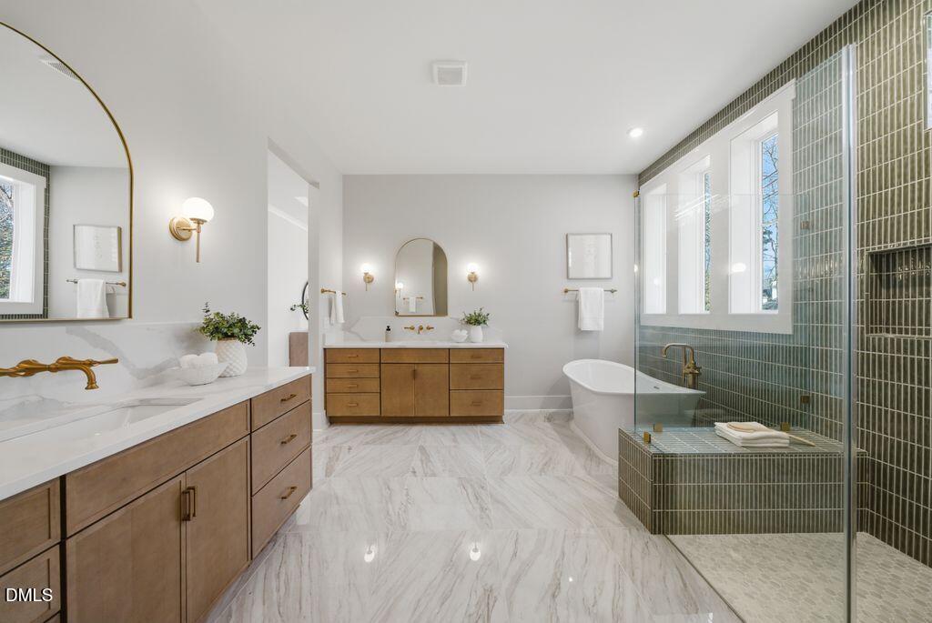 1500 Shadowood Lane Raleigh, NC 27612 - Photo 9 of 39 a spacious bathroom with a double vanity sink a toilet a mirror and shower