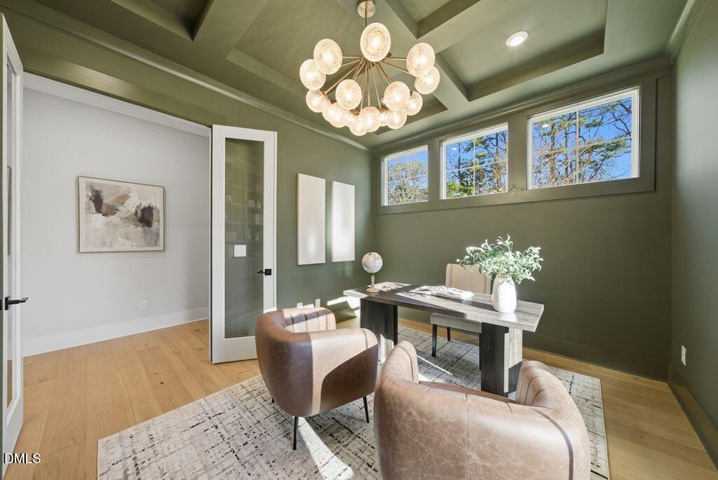 1500 Shadowood Lane Raleigh, NC 27612 - Photo 25 of 39 a dining room with wooden floor a chandelier a wooden table and chairs