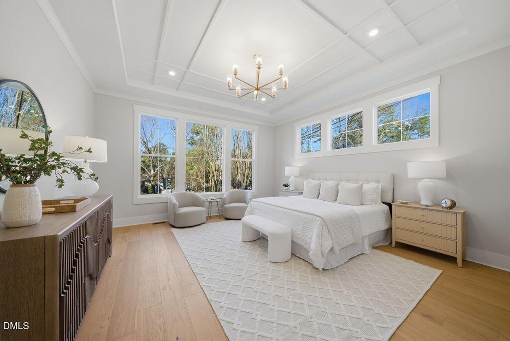 1500 Shadowood Lane Raleigh, NC 27612 - Photo 7 of 39 a spacious bedroom with a bed and a chandelier