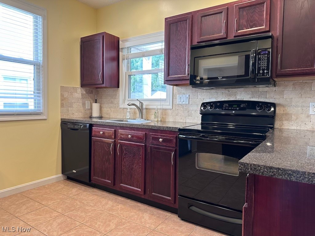 6846 Ottawa Road Cleveland, OH 44105 - Photo 25 of 50 Kitchen with baseboards, a sink, decorative backsplash, black appliances, and dark countertops