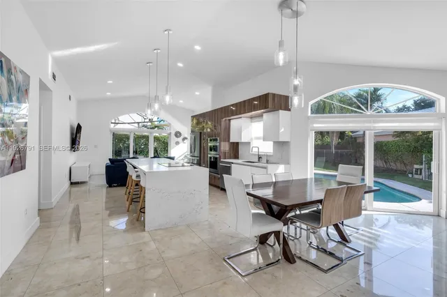 a living room with furniture a large window and stainless steel appliances