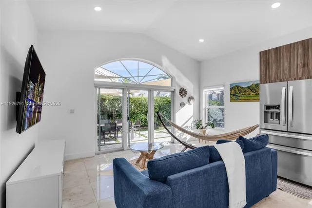a living room with furniture a flat screen tv and a large window