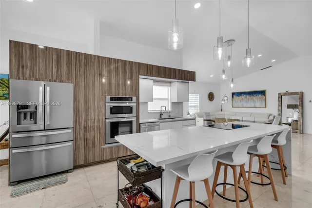 a kitchen with stainless steel appliances a table chairs wooden floors and kitchen view