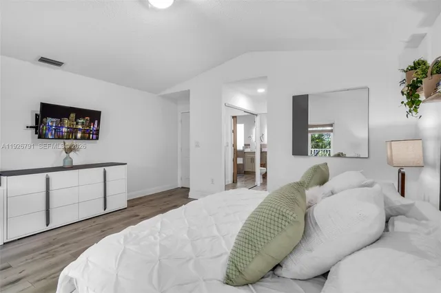 a bedroom with a bed and a flat screen tv