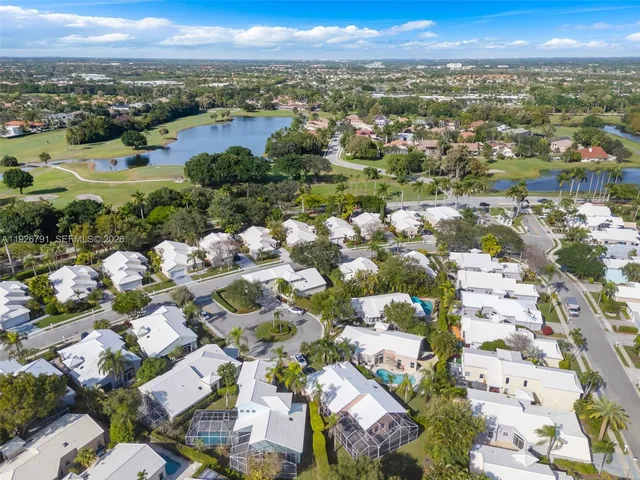 an aerial view of residential houses with outdoor space and trees