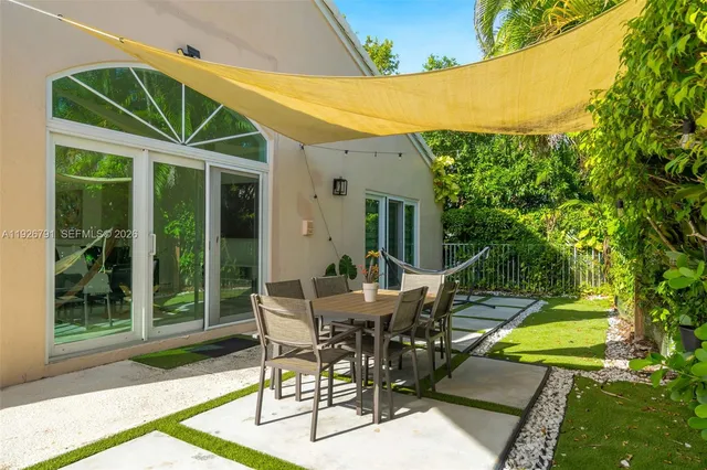 a view of a patio with table and chairs with wooden floor and fence
