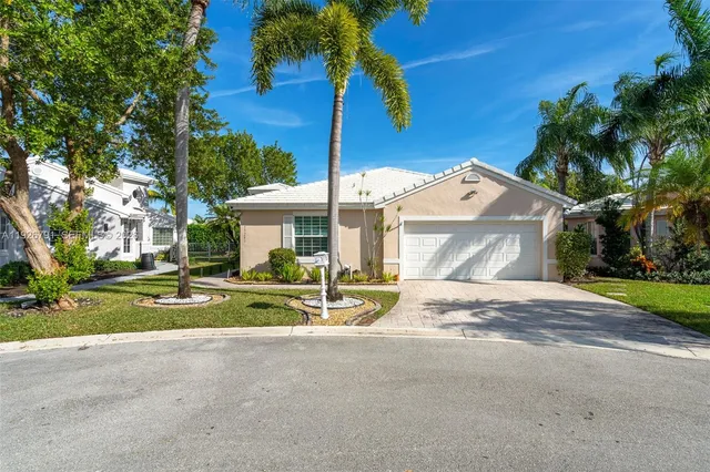 a view of a house with a yard and palm trees