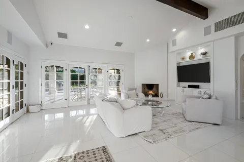 a bed sitting in a spacious bedroom next to a window