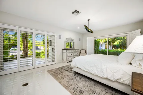 a front view of a house with a yard and potted plants