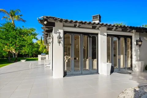 a view of a patio with a table and chairs under an umbrella with a yard