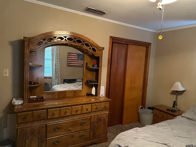 a bedroom with a bed and a mirror on dresser