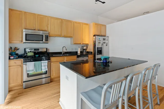 a kitchen with stainless steel appliances granite countertop a sink a stove and microwave