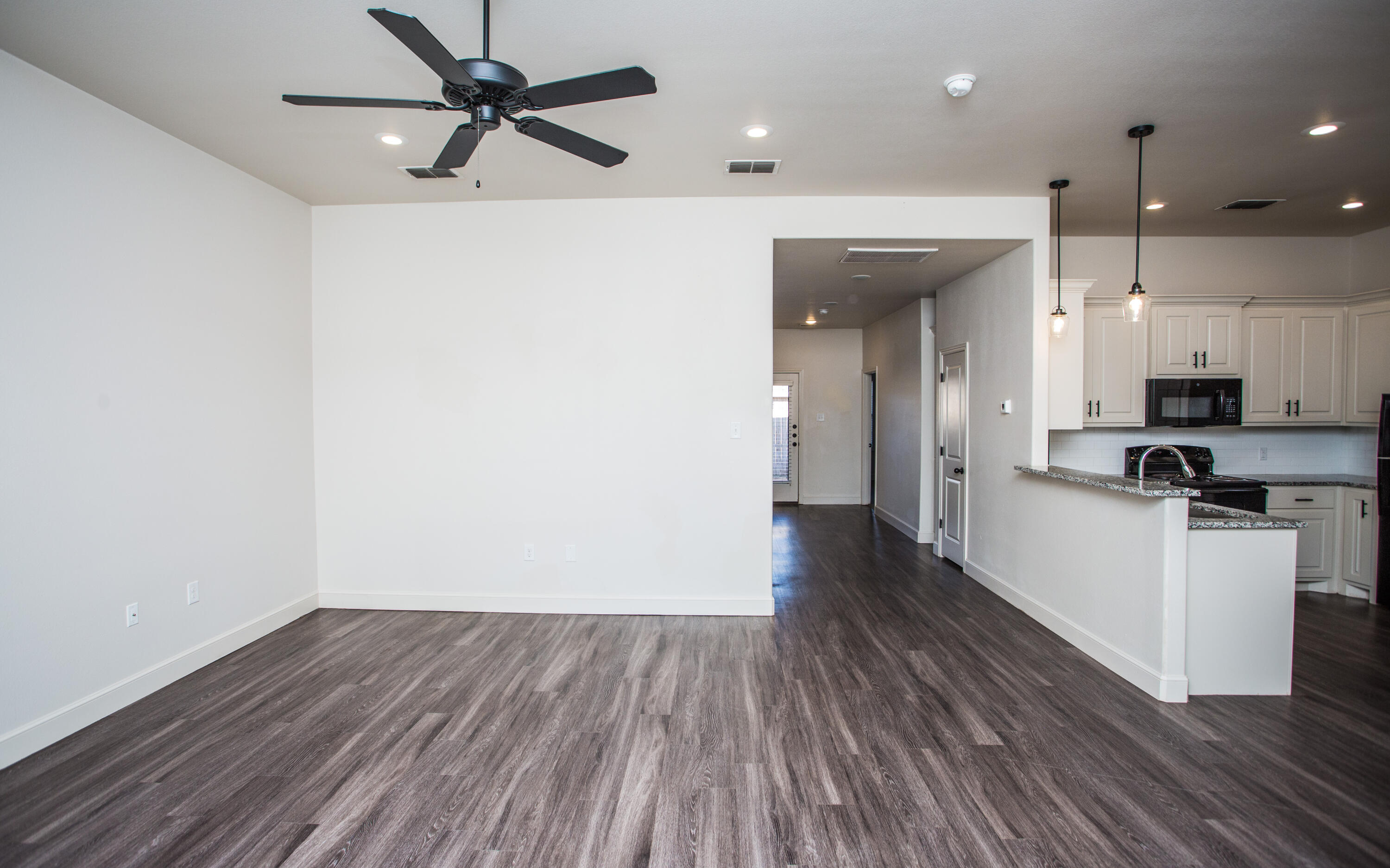 5520 Lehigh Street Lubbock, TX 79416 - Photo 14 of 32 a view of a kitchen with a sink a ceiling fan and wooden floor