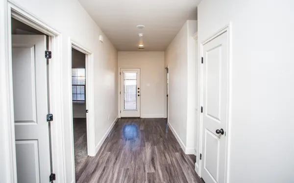 a view of a hallway with wooden floor