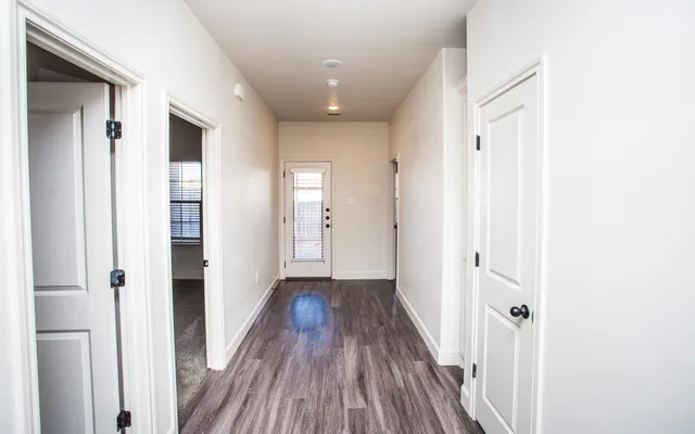 a view of a hallway with wooden floor