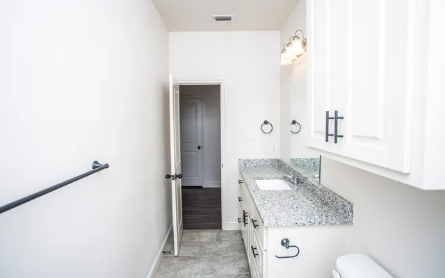 a bathroom with a granite countertop sink and a mirror