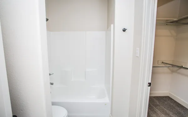a bathroom with a granite countertop shower and a toilet