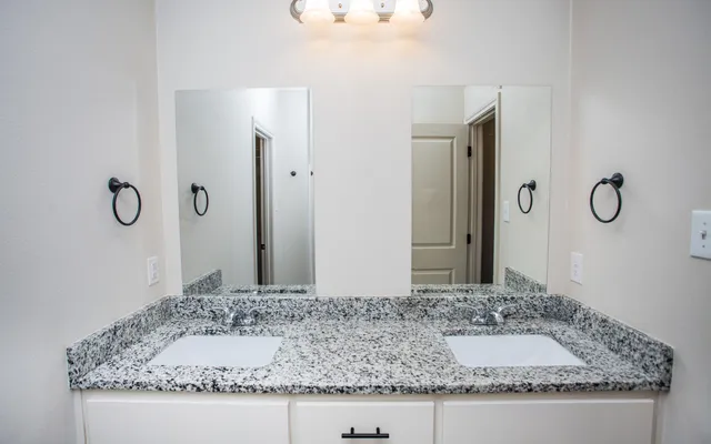 a bathroom with a granite countertop sink and a mirror