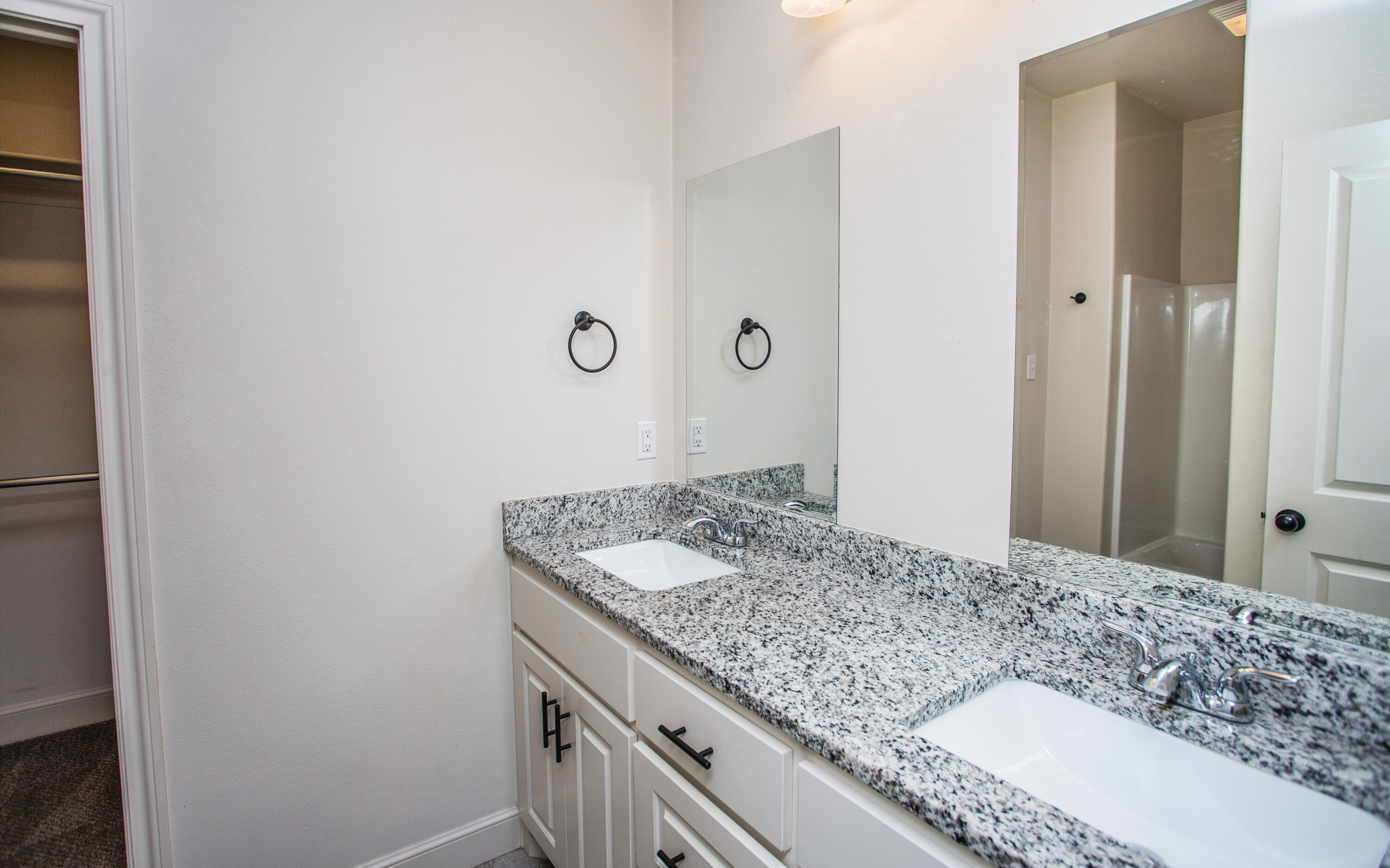 5520 Lehigh Street Lubbock, TX 79416 - Photo 27 of 32 a bathroom with a granite countertop sink and a mirror