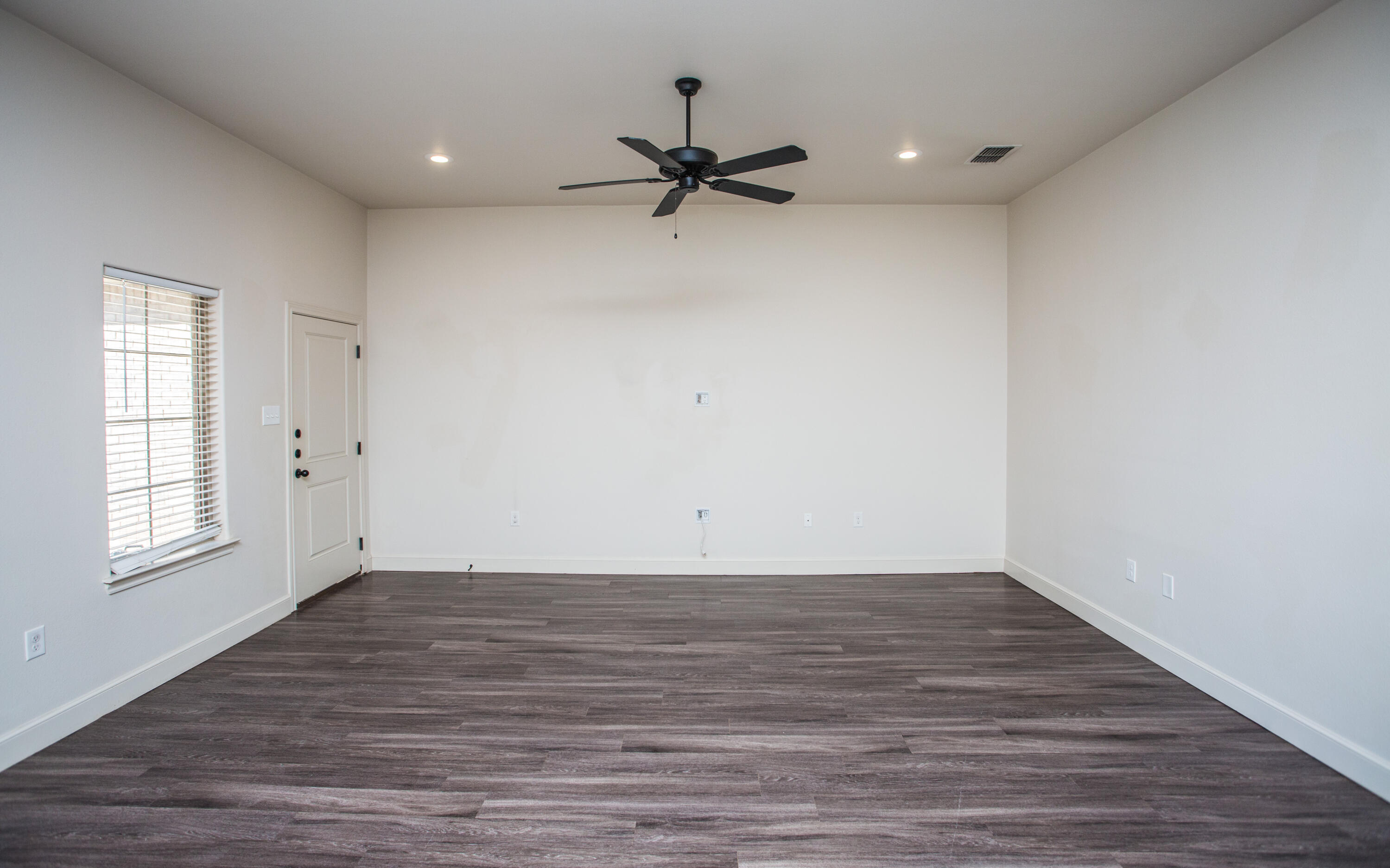 5520 Lehigh Street Lubbock, TX 79416 - Photo 7 of 32 a view of an empty room with wooden floor and a window