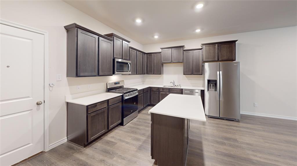 2024 Juniper Pass Way Mesquite, TX 75149 - Photo 10 of 17 a large kitchen with stainless steel appliances kitchen island granite countertop a refrigerator and a stove top oven