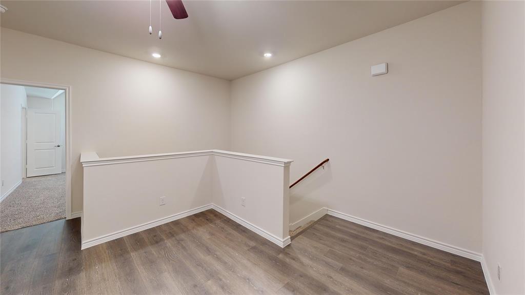 2024 Juniper Pass Way Mesquite, TX 75149 - Photo 9 of 17 an empty room with wooden floor and white walls