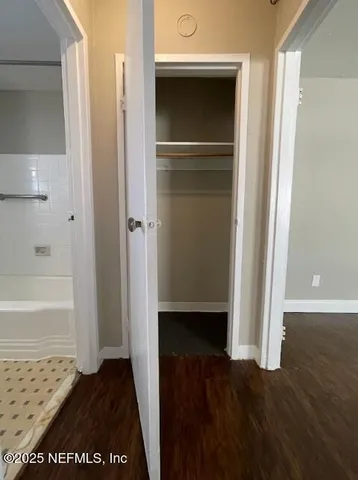 a view of walk in closet with empty room
