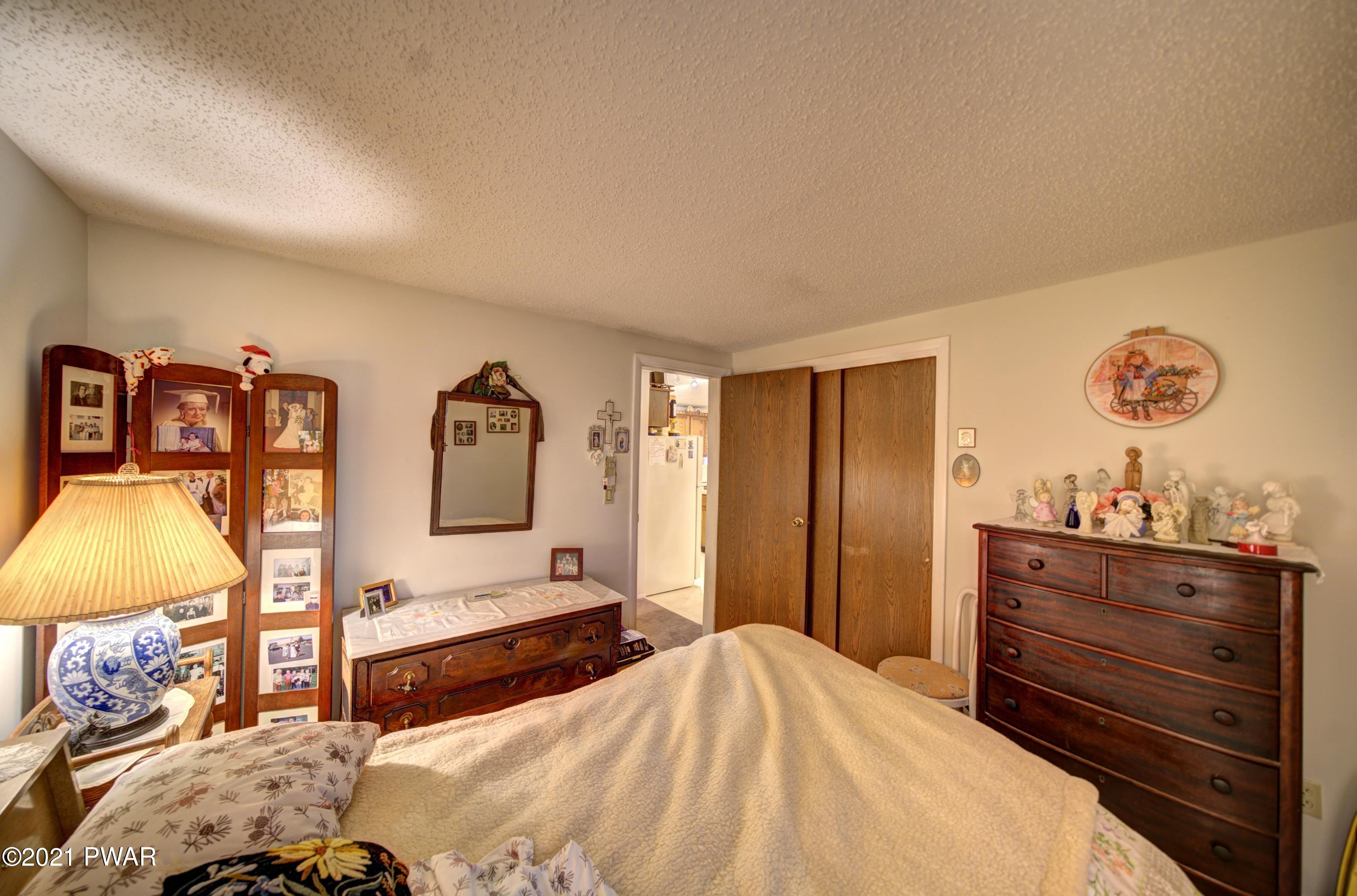 368 Roemerville Road Greentown, PA 18426 - Photo 30 of 59 a bedroom with a bed and a lamp on dresser