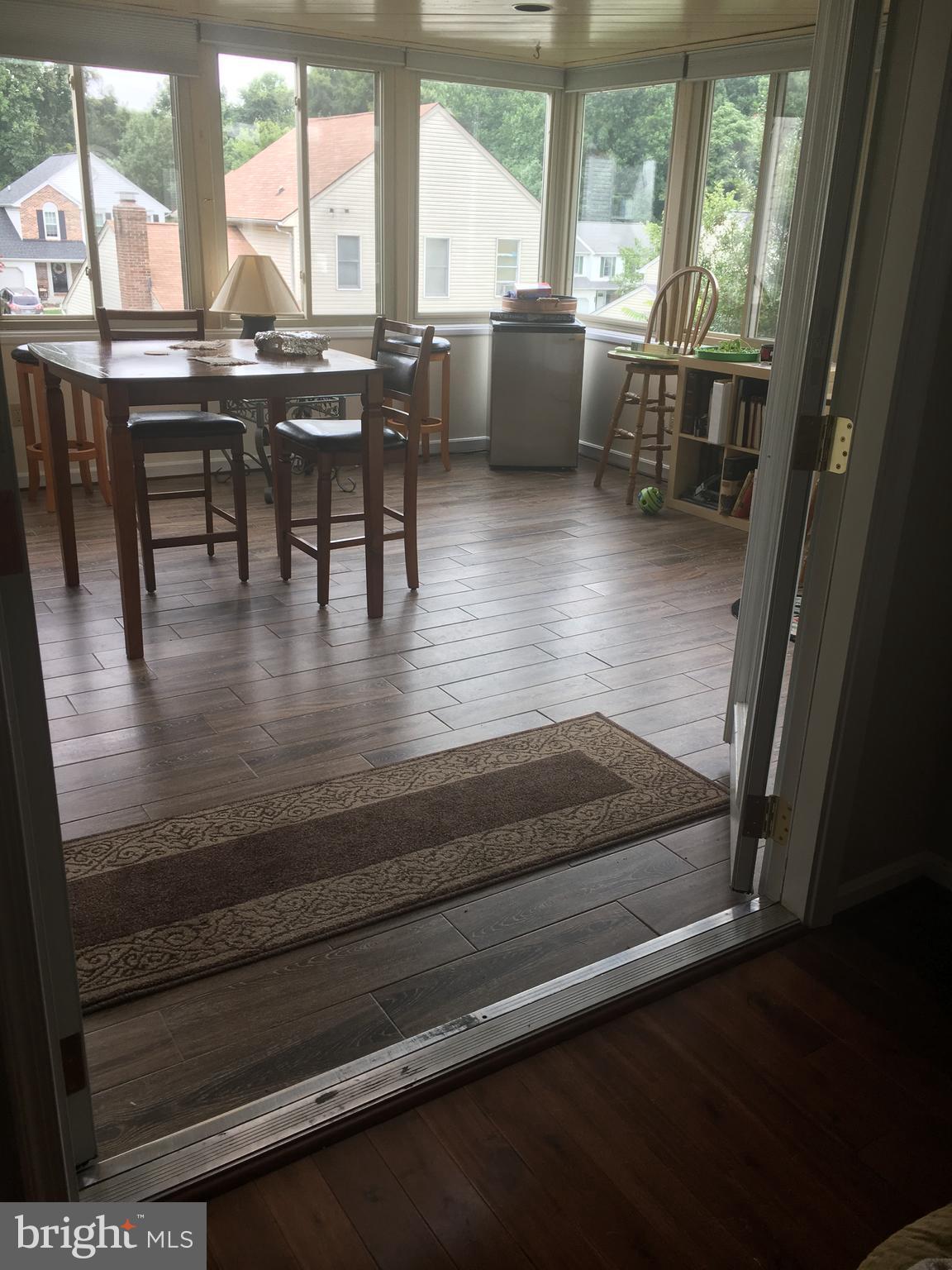 9531 Hallhurst Road Nottingham, MD 21236 - Photo 12 of 30 a view of a dining room with furniture large windows and wooden floor